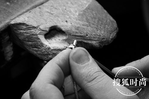 珠宝工匠仔细打造手镯上的金质滚珠